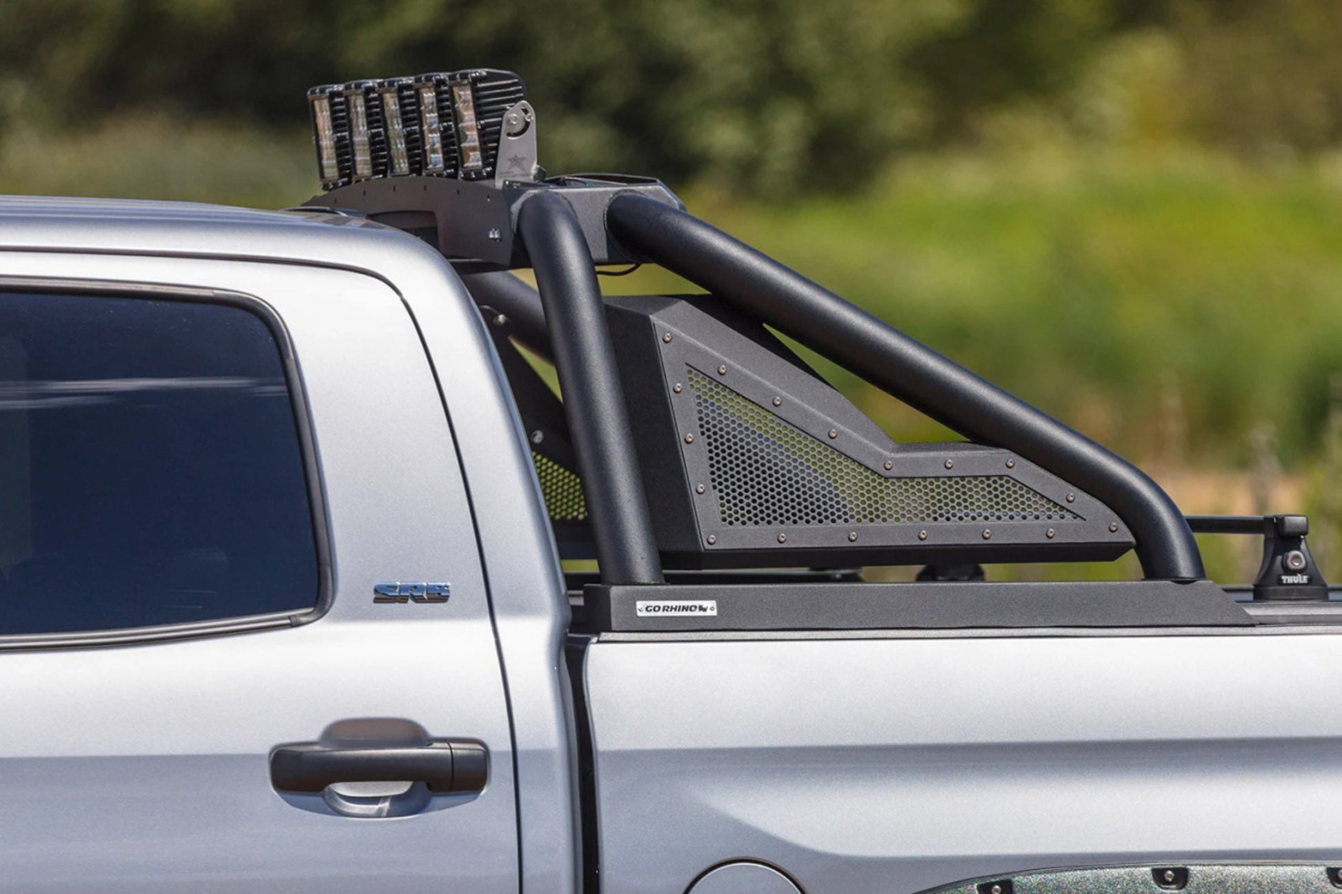 Silver truck with a roof rack and additional equipment in an outdoor setting