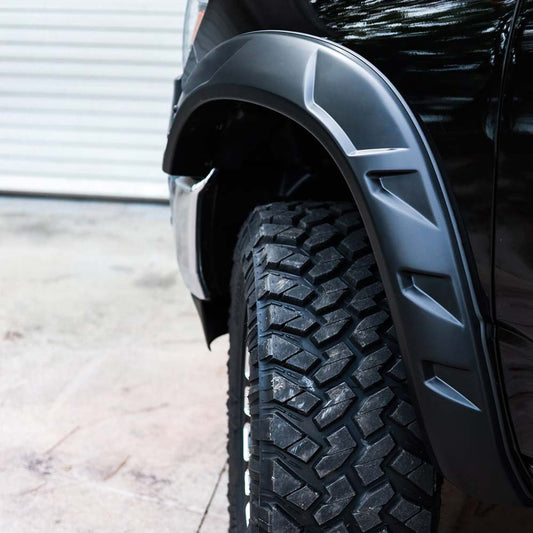 Close-up of a car's tire and fender with a textured tread pattern by Bushwacker DTR Fender Flares on Silverado Z71
