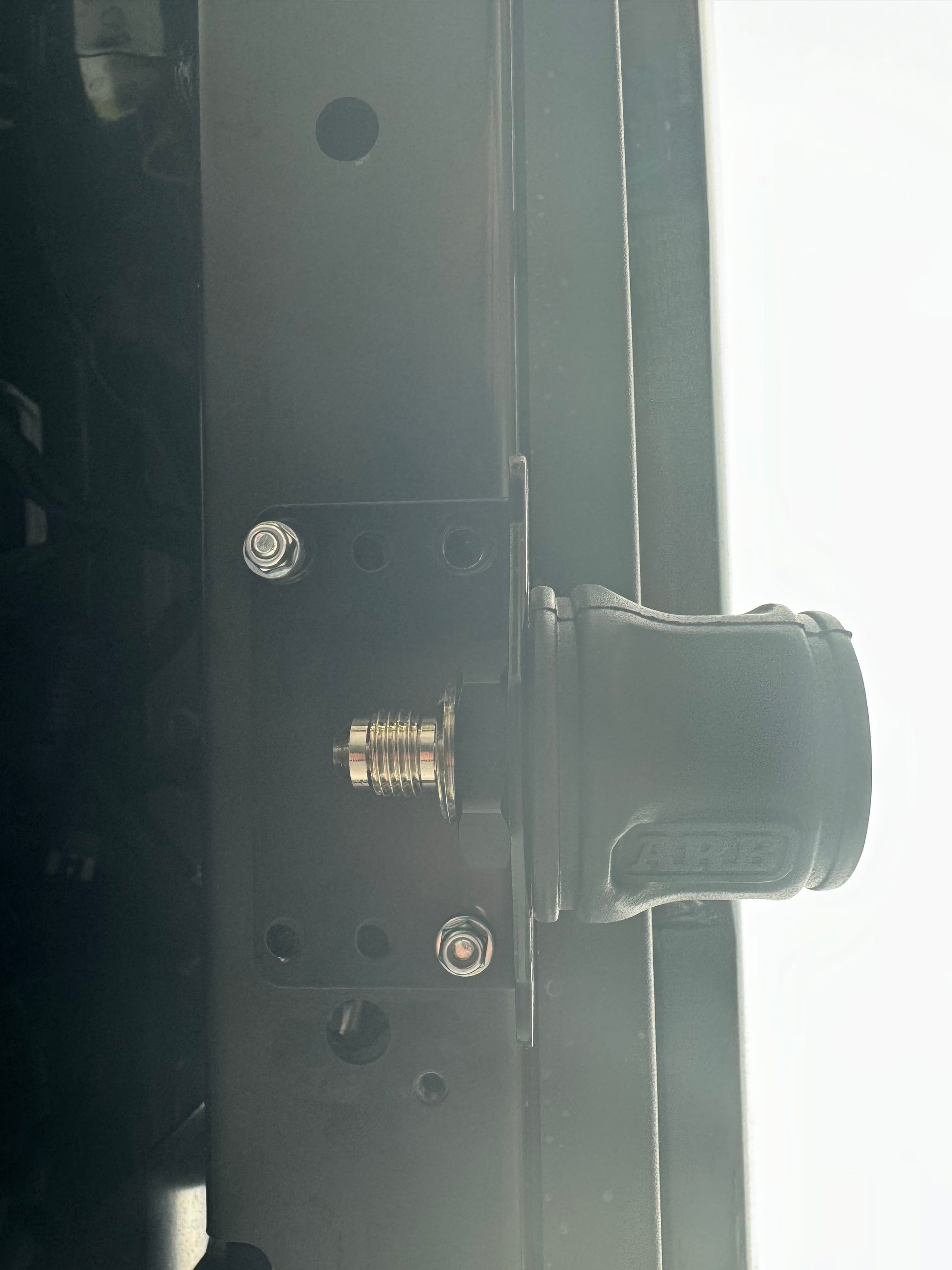 The image shows a close-up of the ARB Air Compressor Coupling Bracket mounted on the rear of a vehicle, with LED lights visible above it.
