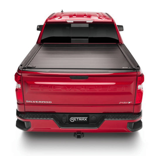 Red Chevrolet Silverado truck with a Retrax tonneau cover on a white background