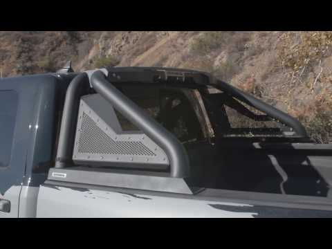 Roof rack system on a vehicle with a mountainous landscape in the background with a Go Rhino Sports 2.0 Roll bar