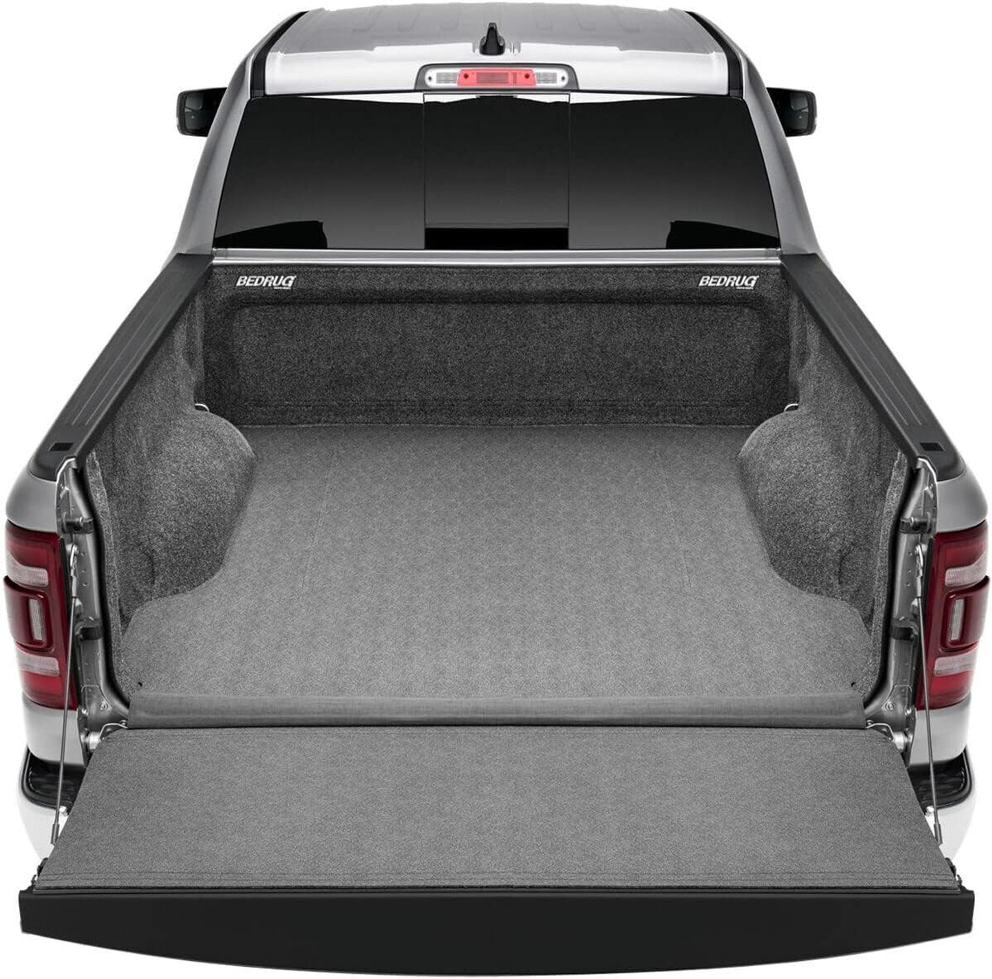 Truck bed with a gray mat and open tailgate, featuring BedRug branding.