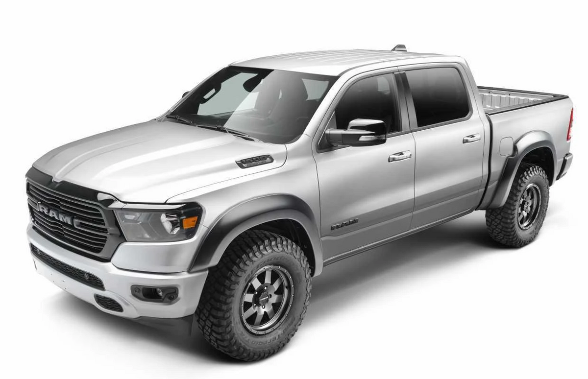 A silver Ram pickup truck with husky extend-A-Flares, shown from a three-quarter front angle on a white studio background.