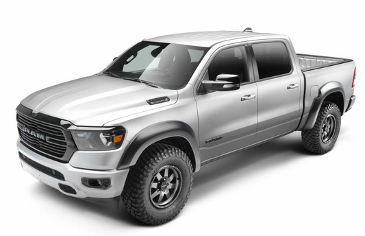 A silver Ram pickup truck with husky extend-A-Flares, shown from a three-quarter front angle on a white studio background.