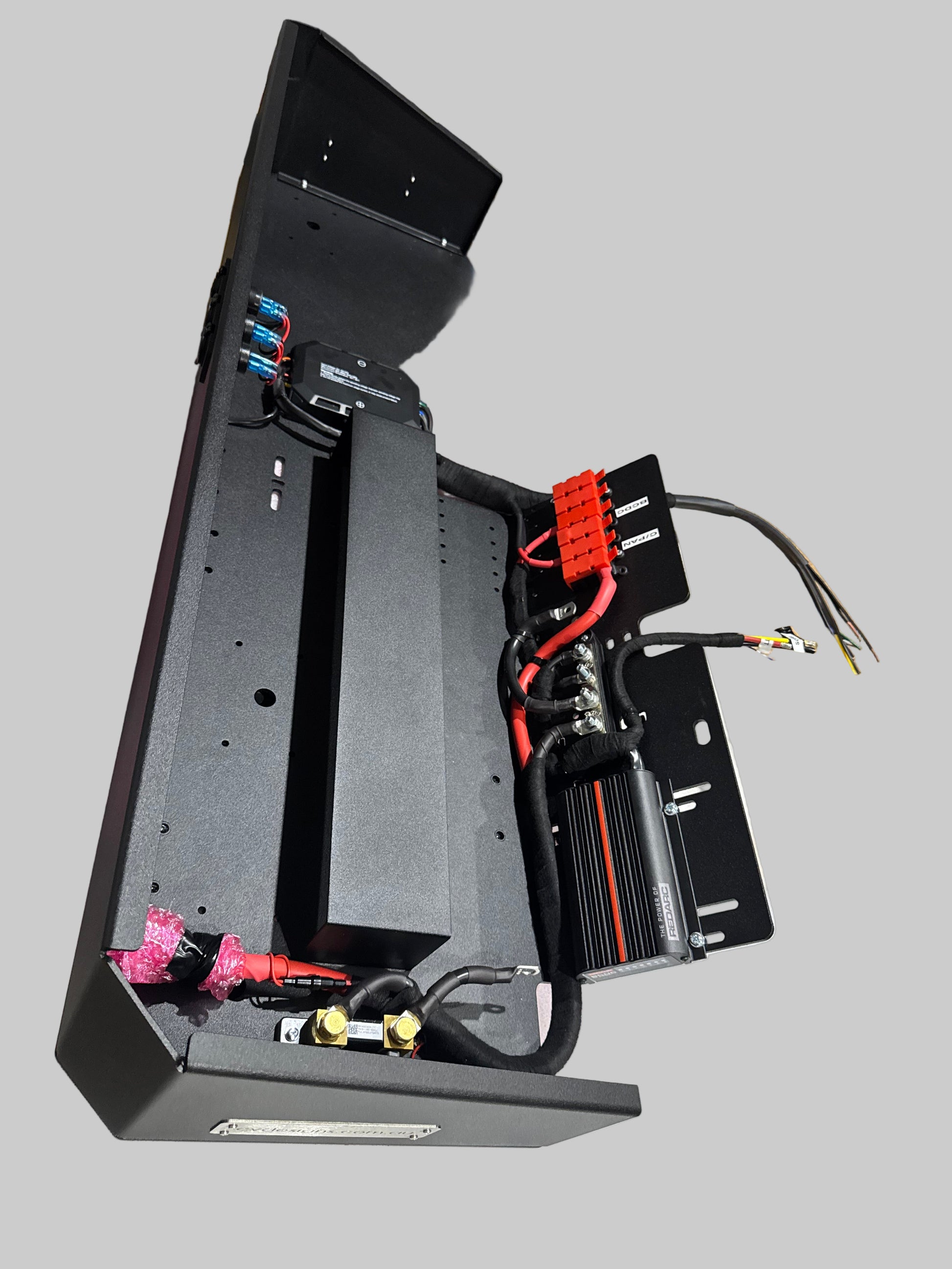 Electrical panel with wiring and components on a cluttered workbench.