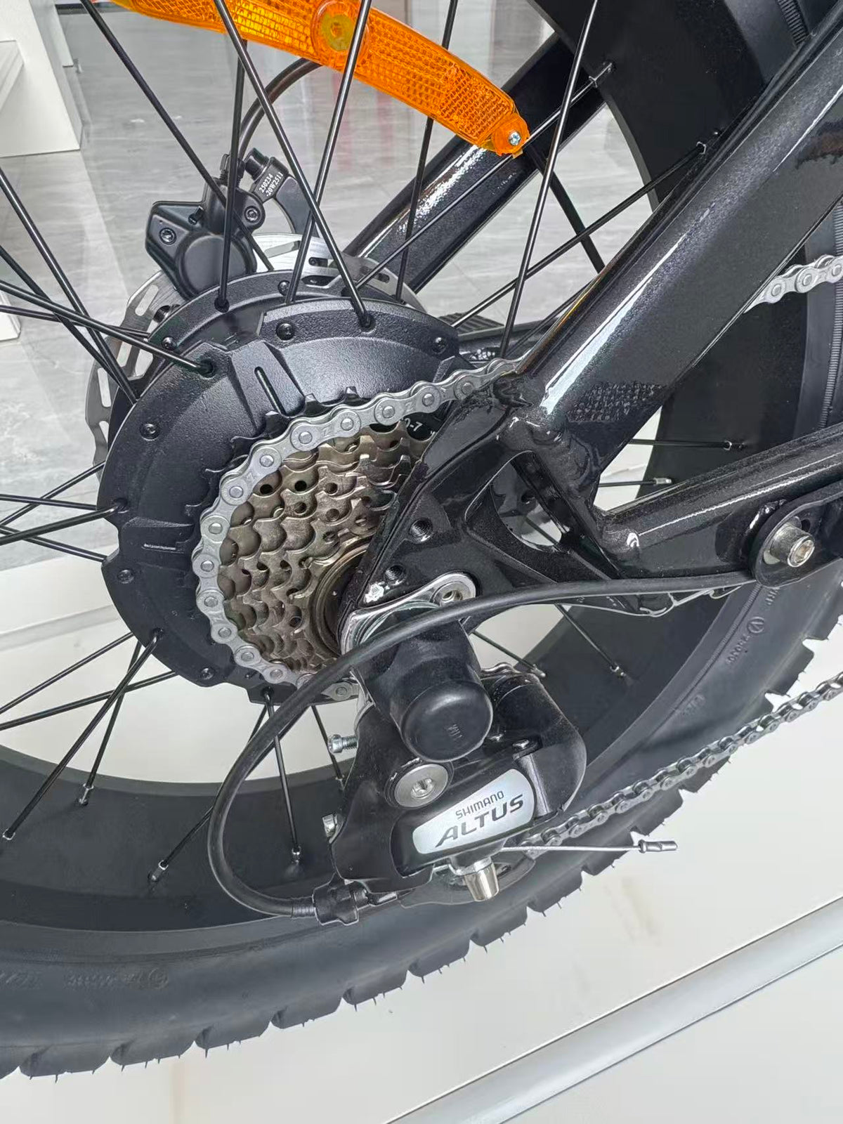 Close-up of an e-bike rear wheel derailleur by Shimano Altus on a Lazy Boy E-bike Cruiser